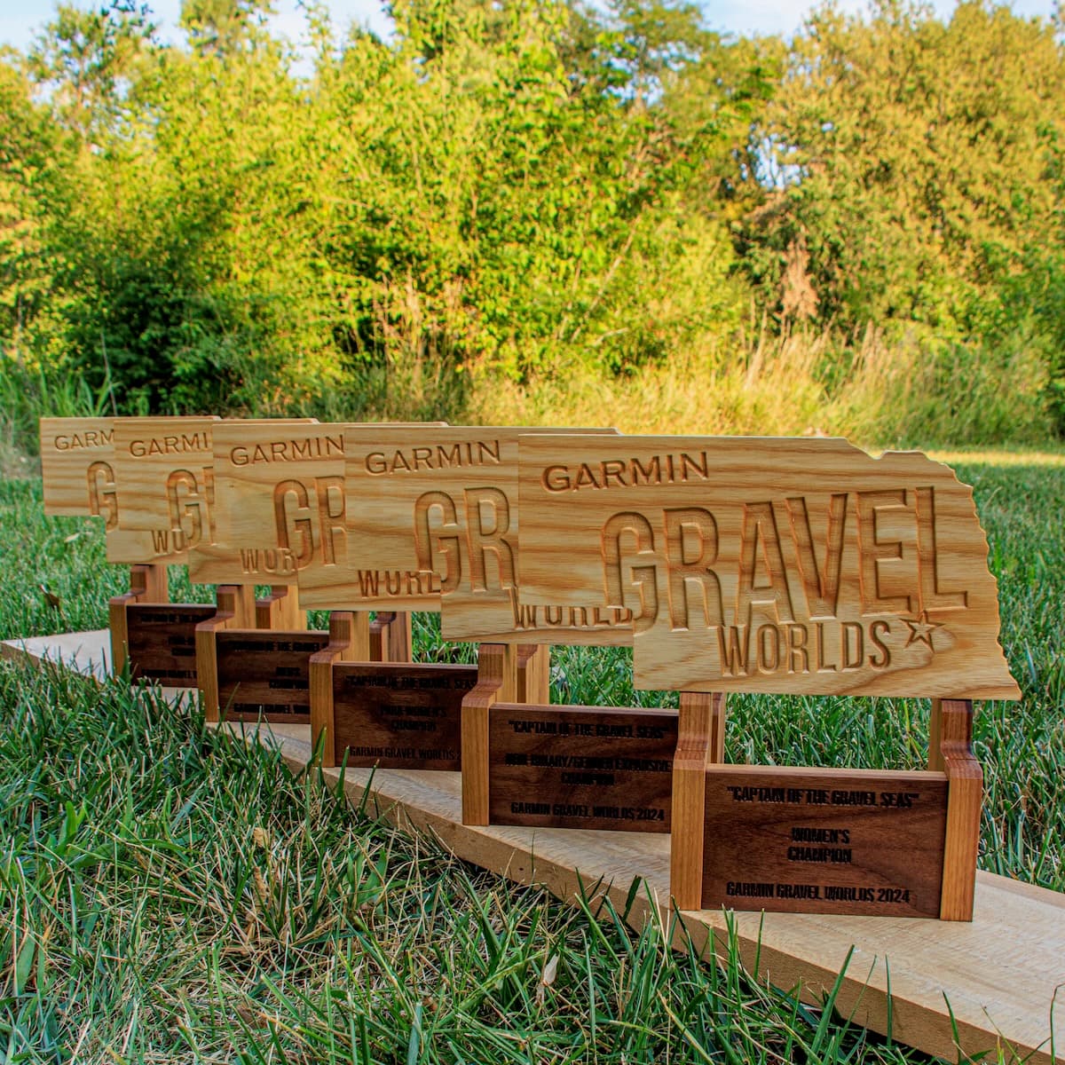 Angled side view of five Garmin Gravel Worlds wooden trophies with darker engraved plaques, showing detail of engraving