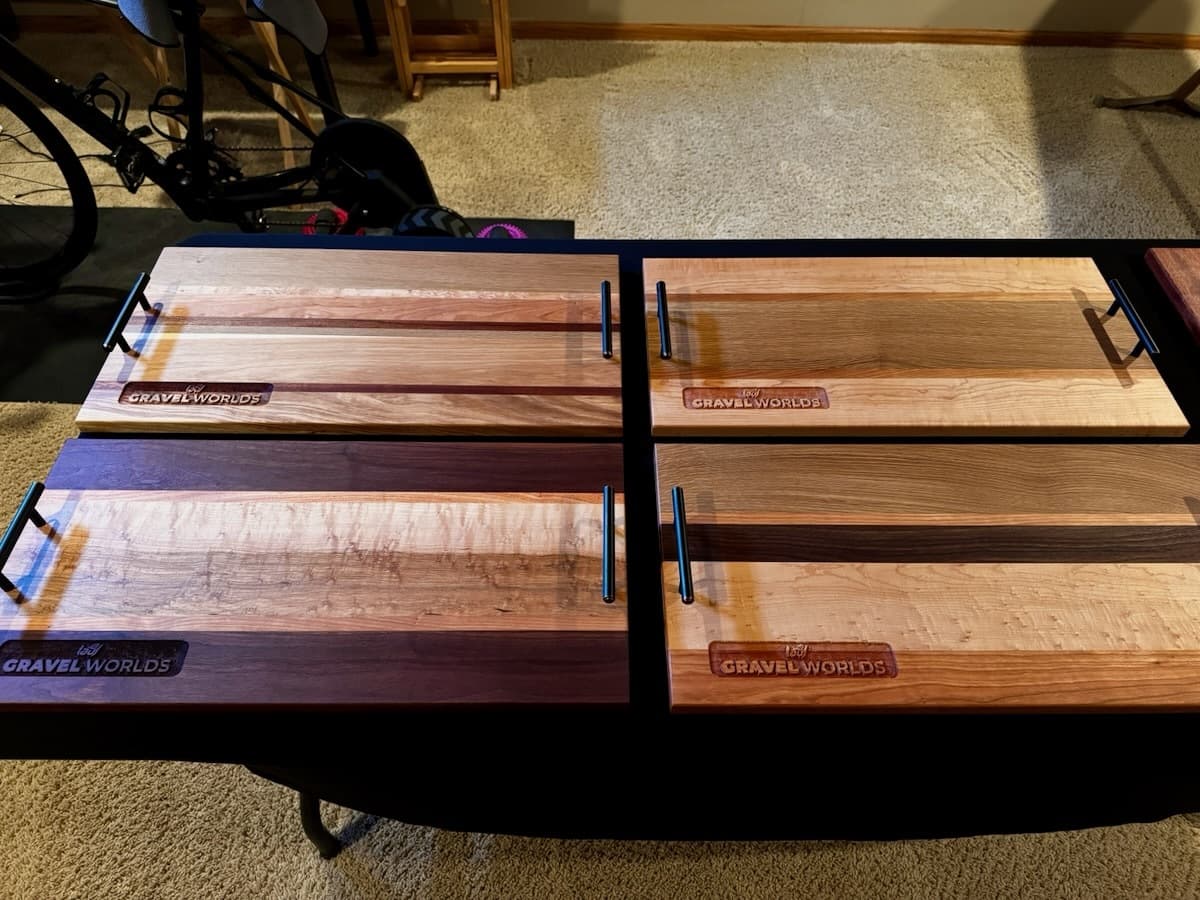 Four wooden Gravel Worlds trophy plaques displayed side by side, showing varied wood species and finishes with engraved logos