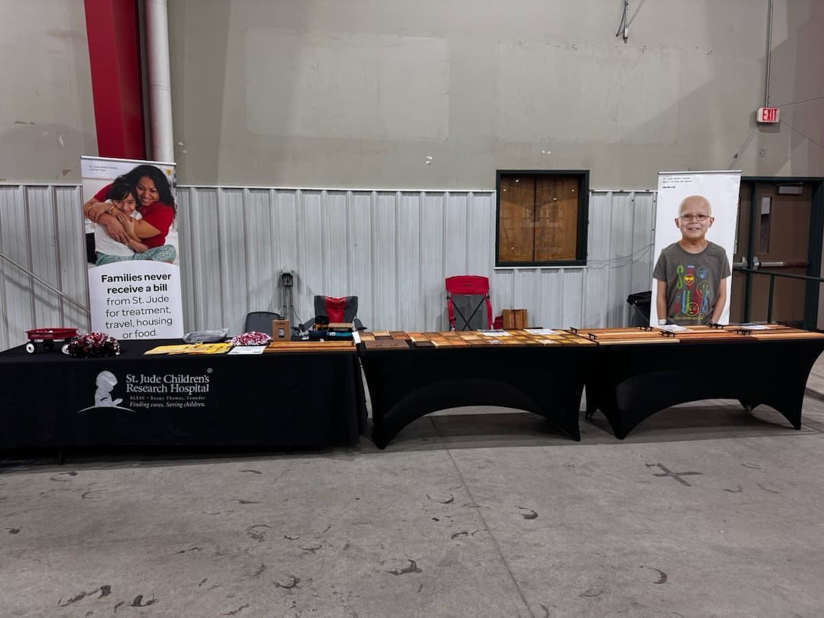 Bib holder plaque for Wahoo Runner Bags with engraved wood branding and raffle information displayed at event booth