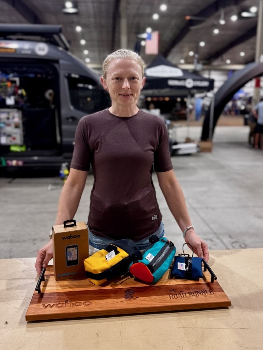 Woman holding wooden Wahoo Road Runner wooden display plaque with engraved branding at Gravel Worlds Expo cycling event