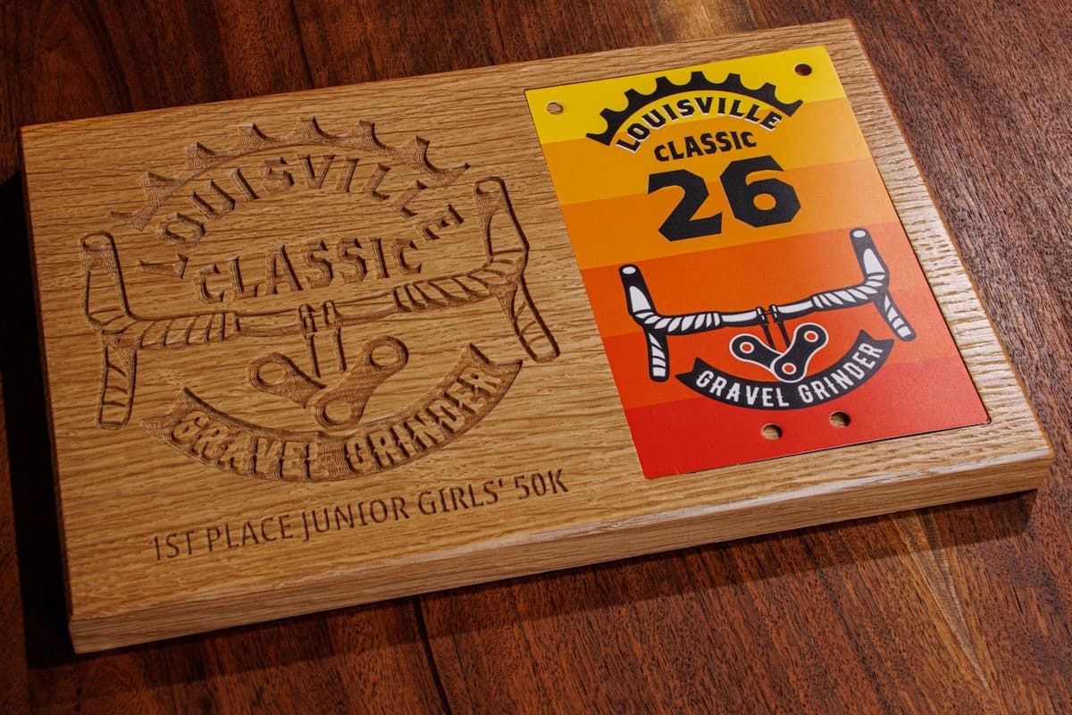 White oak trophy plaque with engraved Louisville Classic logo, sword graphic, and winner category text on wooden base