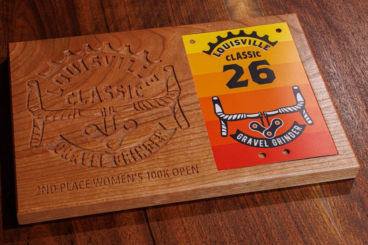 Cherry wood trophy plaque featuring engraved Louisville Classic Gravel Grinder branding with sword design and race category text