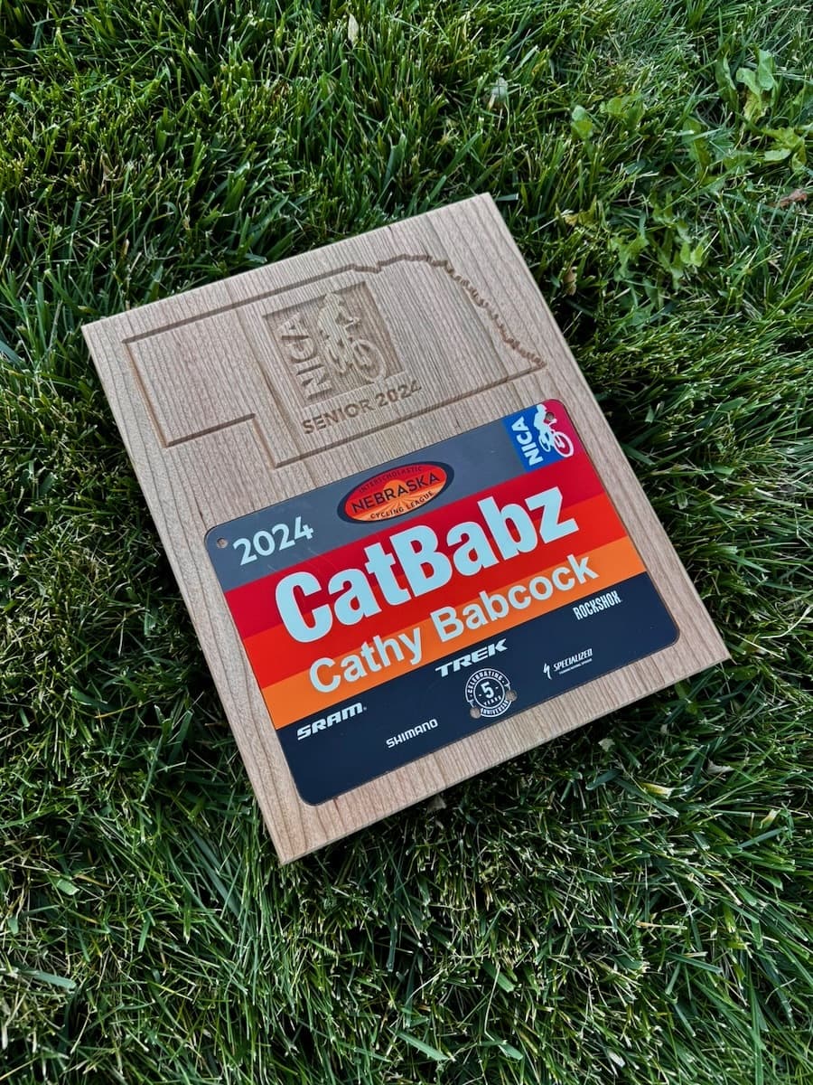 Cherry wood NICA award plaque with CNC-engraved design and number plate holder slot for Cathy Babcock, 2024 Nebraska Cycling Association award