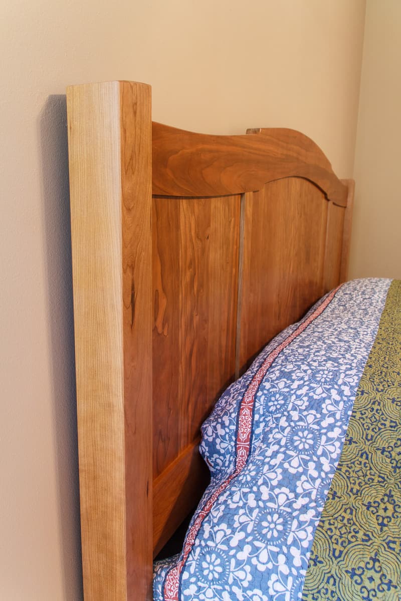 Cherry bed headboard side post with curved rail and panel joinery