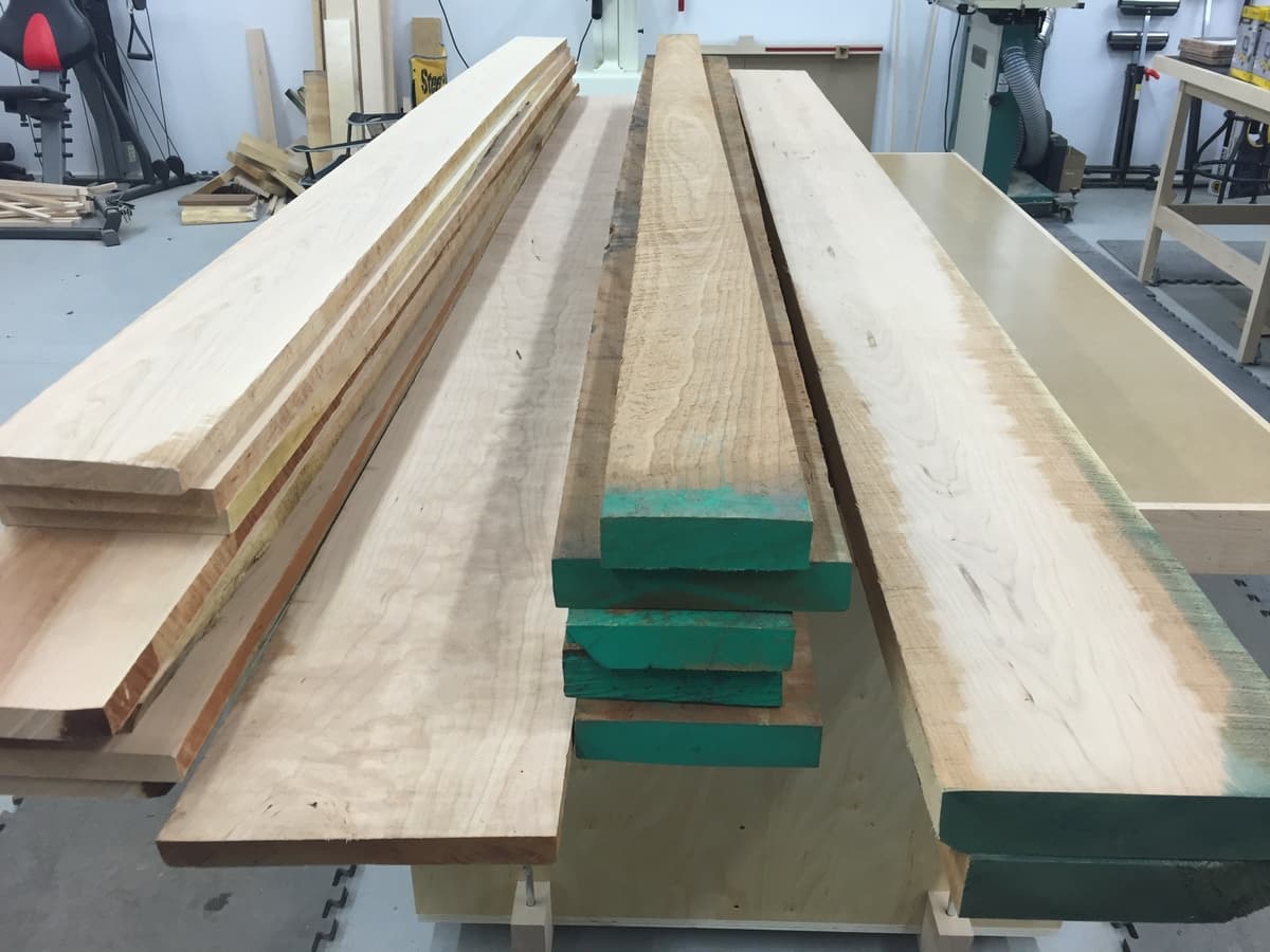 Workshop lumber rack with various milled wood strips and green stickers