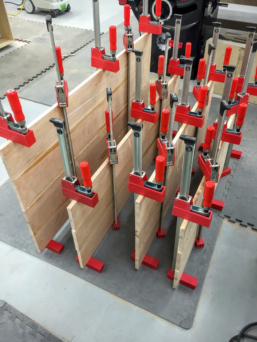 Wooden bed panels clamped in vise during panel construction phase