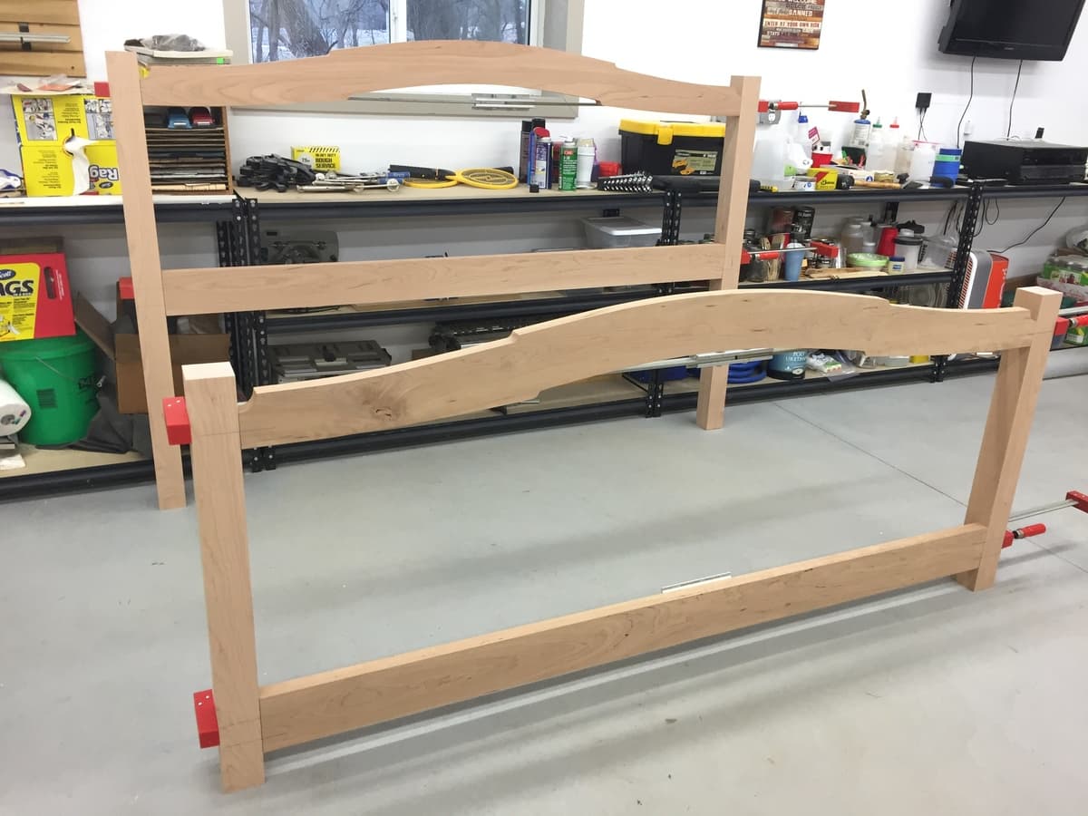 Headboard and footboard assembly frame in workshop with curved rails