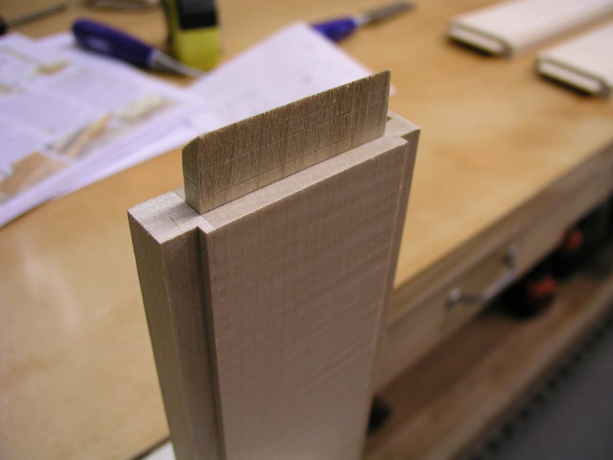 Detailed close-up of mortise and tenon joinery assembly showing wood fit and traditional joinery craftsmanship on cherry and maple