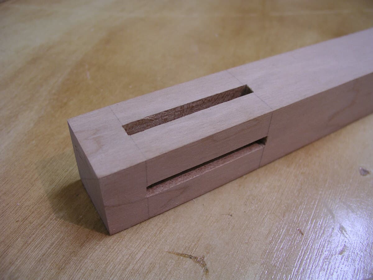 Mortise and tenon joint assembly in wood clamps during glue-up, showing precision craftsmanship and traditional woodworking techniques