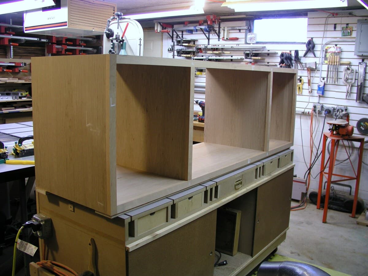 Work-in-progress TV stand frame showing mortise and tenon joinery construction in the workshop with tools visible