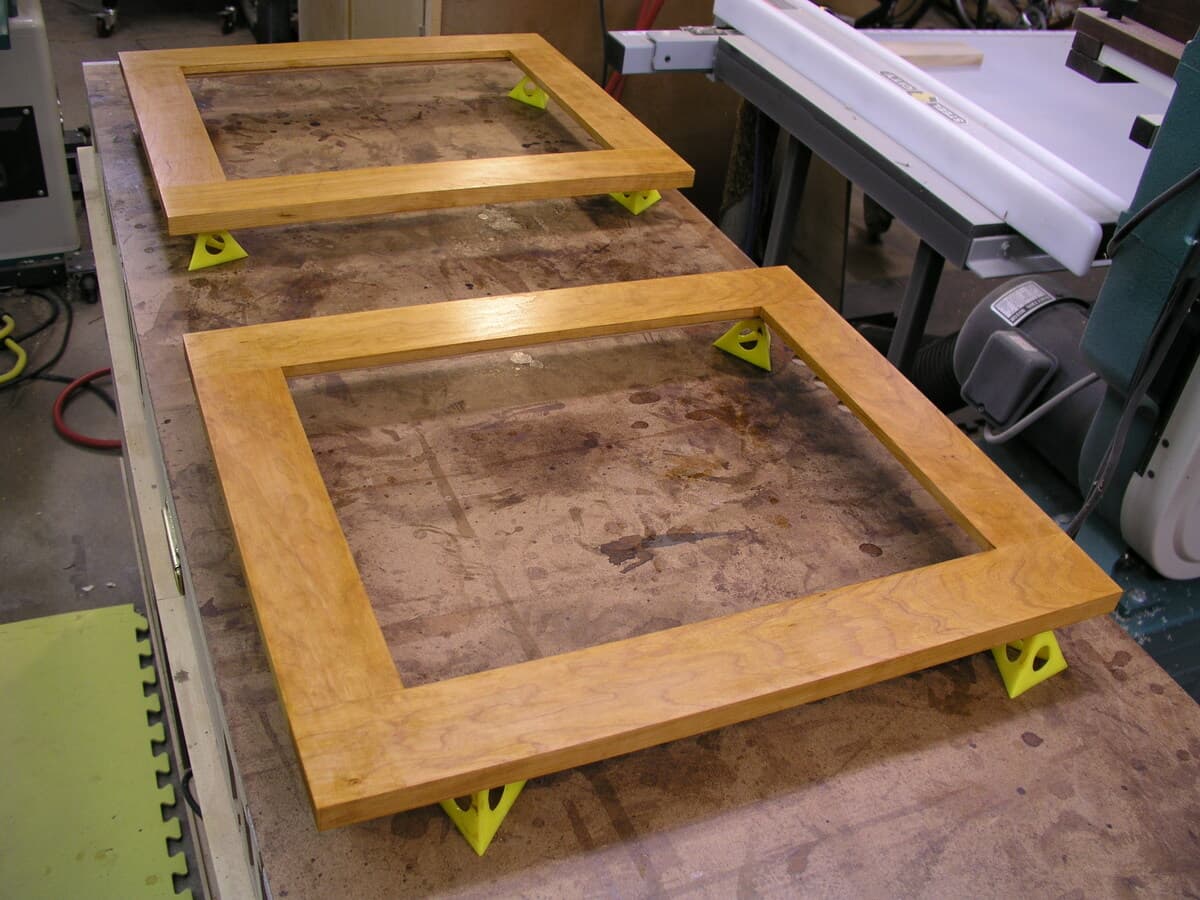 Glass panel door frames in the workshop with mortise and tenon joinery details visible