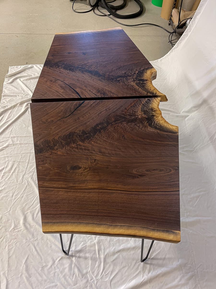 Single live edge walnut end table photographed from above highlighting the distinctive bookmatched grain and organic curved edges