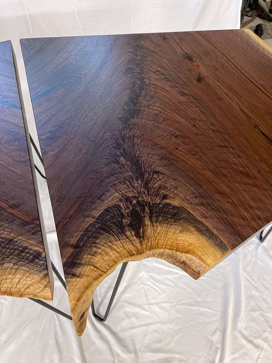 Detail shot of bookmatched crotch grain on live edge walnut showing complex curved grain lines with honey and dark brown tones