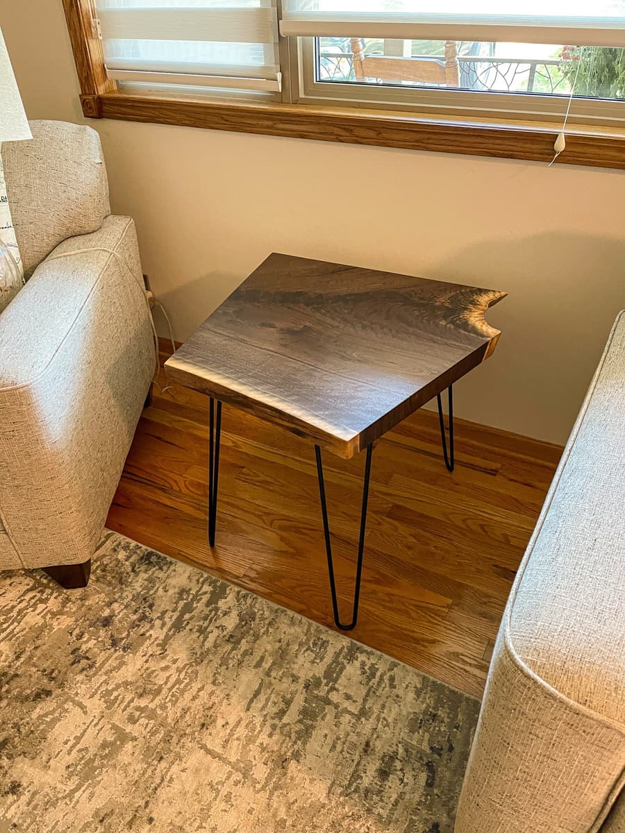 Single live edge walnut end table in residential interior with hairpin legs and visible crotch grain figuring on walnut top