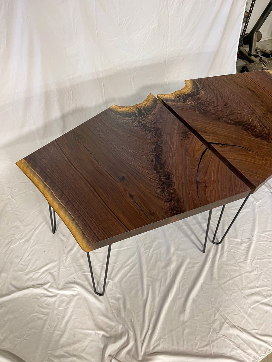 Pair of live edge walnut end tables with bookmatched crotch grain pattern and natural honey-golden edges, displayed on hairpin legs