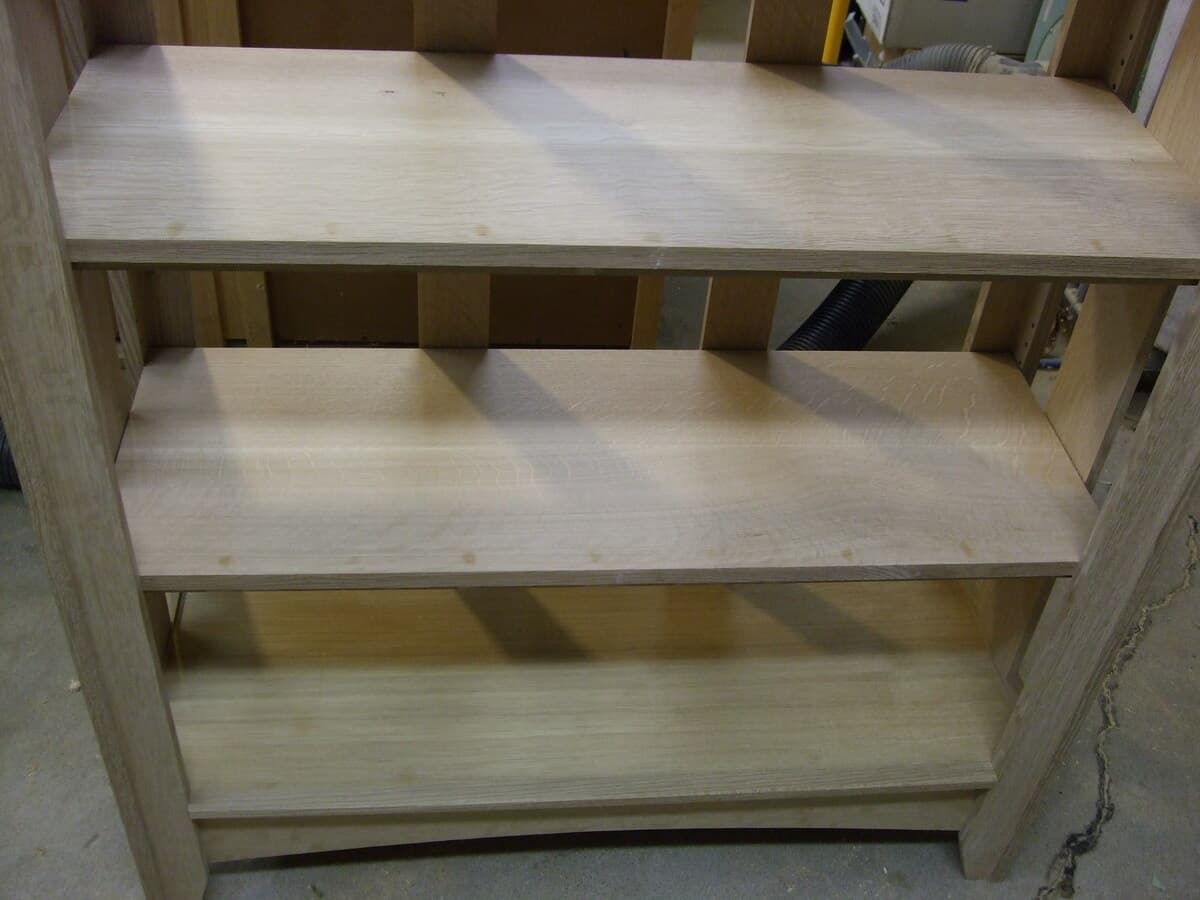 Close-up detail of assembled mission bookcase shelves showing clean lines and balanced proportions, with two finished shelves visible against the quarter-sawn oak frame
