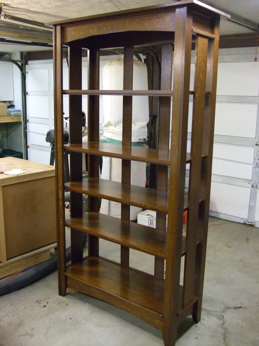 Close-up detail of finished mission bookcase shelf surface showing the warm amber tones and distinctive quarter-sawn white oak ray fleck pattern after Shellac and Waterlox Satin finish
