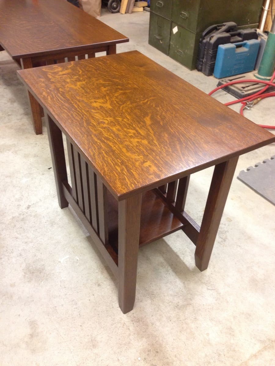 Finished mission furniture set showing multiple tables with similar design and warm wood tone