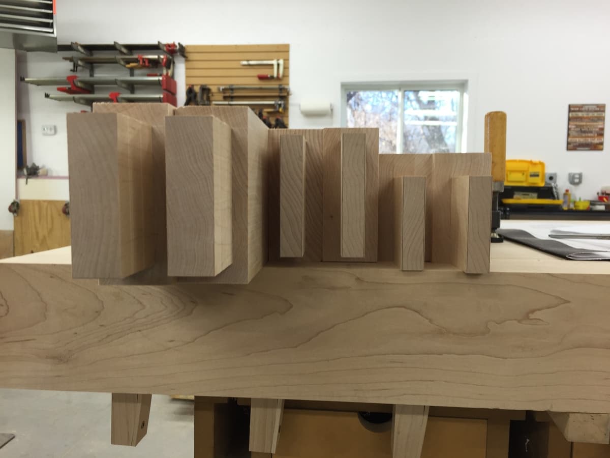 Workshop view showing base assembly during dry-fit with red clamps securing mortise-and-tenon joints