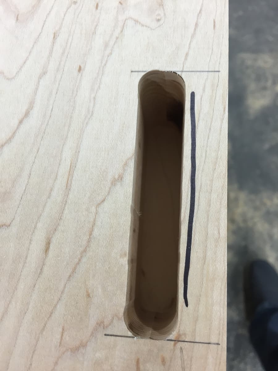 Close-up of through-mortise double-wedge joinery detail showing hard maple tenons and geometric grain pattern