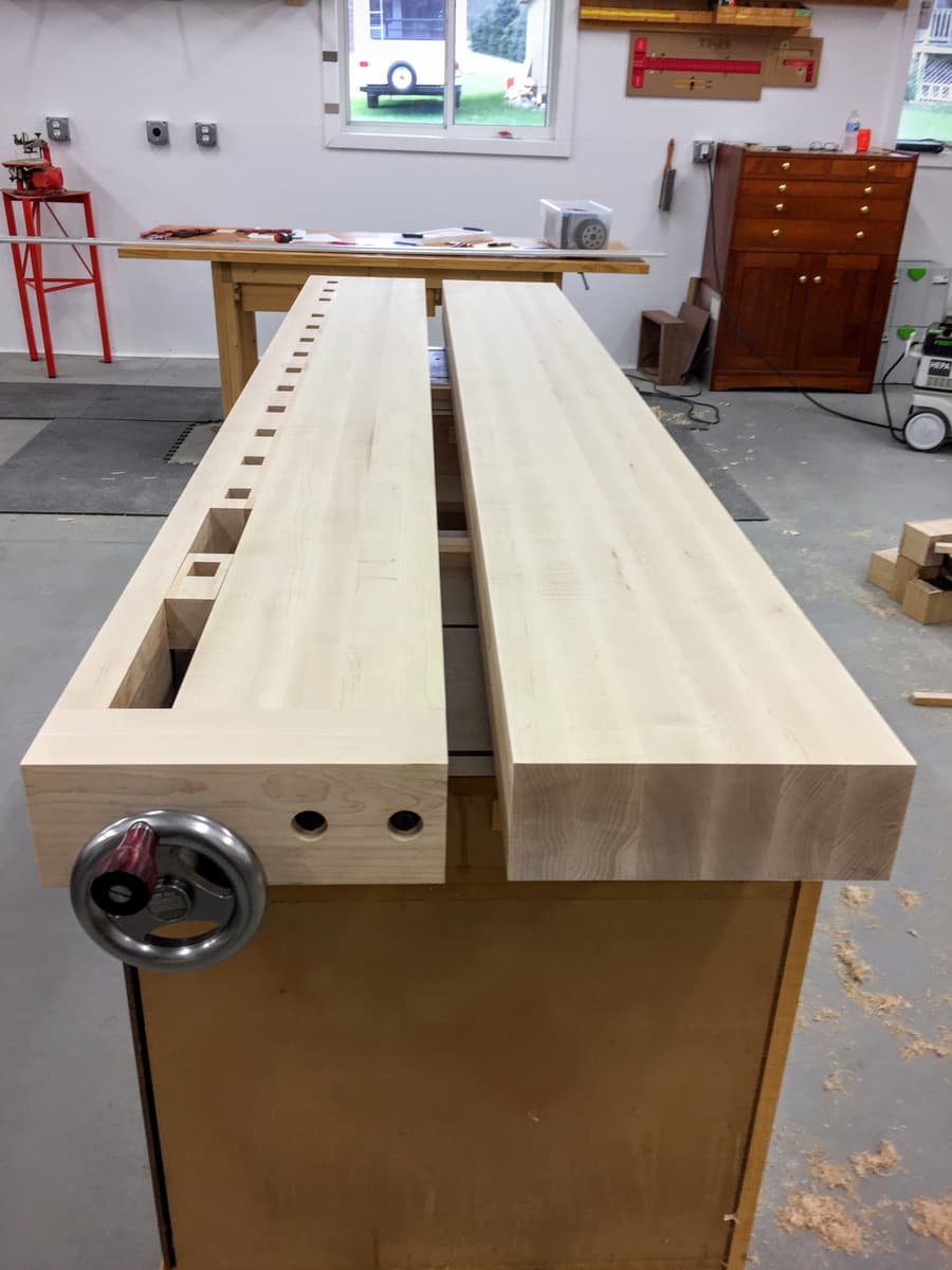 Overhead view showing row of hard maple benchtop slabs with multiple dog holes visible