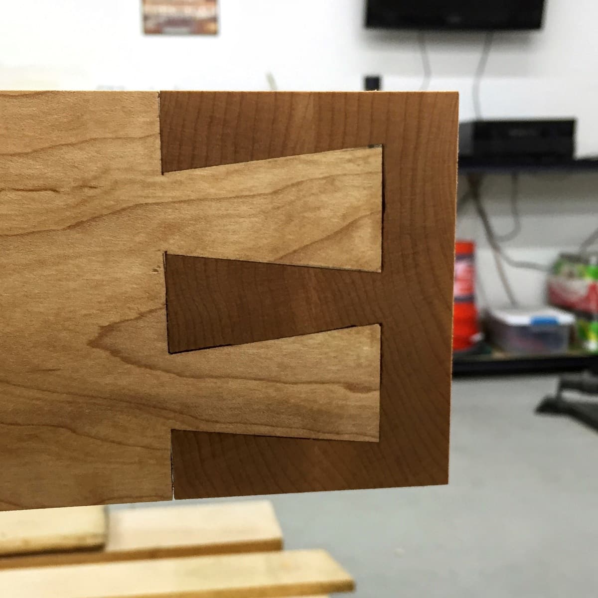 Close-up of hand-cut dovetail joint showing traditional joinery between hard maple components